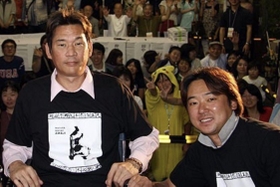 ２００８年に西神戸センター街で開かれた震災復興イベントで写真に納まる仲田幸司さん（左）と安達智次郎さん（西神戸センター街提供）＝神戸市長田区双葉町