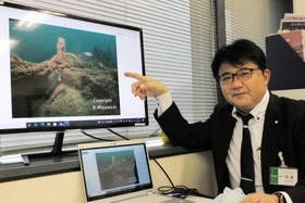 写真を見ながら調査の成果を説明する宮道成彦さん＝神戸市役所