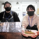 キッチンカーで販売する鹿肉ロースト丼を手にするあかりんごさん（右）と花尻全弘さん＝大阪市内