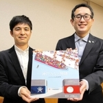 コンテナをテーマとした神戸港の絵本を寄贈した（右から）青山大介さんと谷川夏樹さん＝神戸市役所