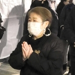 夫の隆さんに祈りをささげる池田美代子さん。優しい人柄をしのんだ＝１７日午前、神戸市長田区日吉町５