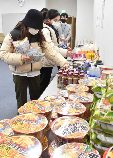 さまざまな種類の食料品から必要なものを選ぶ学生たち＝神戸市西区学園西町１