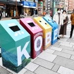 ぽい捨てゼロを目指してさんきたアモーレ広場に設置された「仕掛けごみ箱」と、手掛けた県立大の学生ら＝神戸市中央区加納町４（市提供）