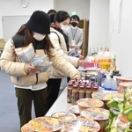 さまざまな種類の食料品から必要なものを選ぶ学生たち＝神戸市西区学園西町１