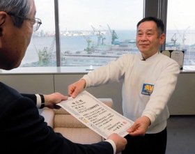 神戸新聞社の高梨柳太郎社長（左）から表彰状を受け取る「クリーンアップ関西事務局」共同代表の原賢治さん＝神戸市中央区東川崎町１