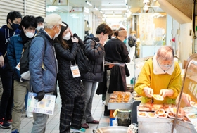 市場を散策し、陳列された総菜を選ぶ参加者たち＝神戸市兵庫区東山町２