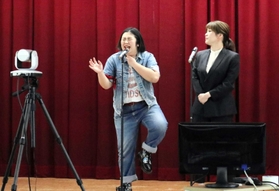 １８歳成人を前に開かれたオンラインイベントで、食べ物の誘惑から逃れようとする漫才を繰り広げた芸人ら＝県弁護士会館