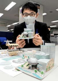 神戸市東灘区が無料配布する「神戸ファッションプラザ」のペーパークラフト（手前）＝同区役所