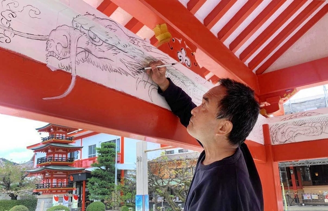 手水舎の内側に竜の下絵を描く山内章さん＝綱敷天満宮