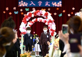 花道を通って会場入りする新入生＝千代が丘小学校（撮影・中西幸大）