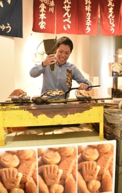 野球カステラ展の会場をＰＲする志方功一さん＝神戸市中央区三宮町１