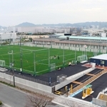 サッカーコート２面分の広さを誇るグラウンド（左）を備えた港島南球技場＝神戸市中央区港島南町３