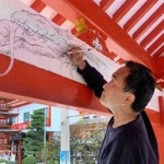 手水舎の内側に竜の下絵を描く山内章さん＝綱敷天満宮