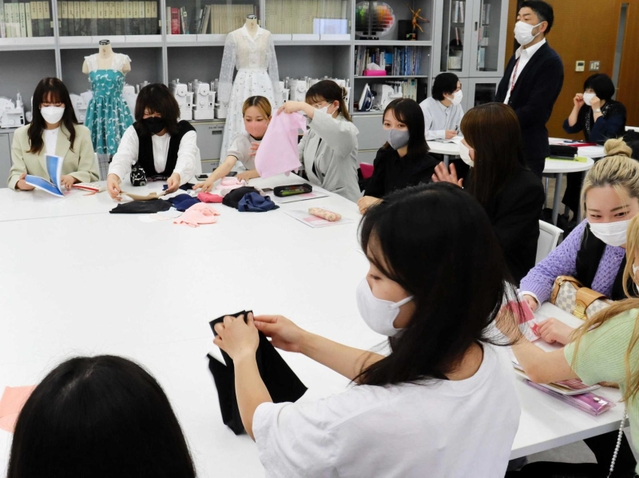 ユタックスの商品を手に取る神戸松蔭女子学院大生＝神戸市灘区篠原伯母野山町１