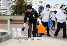 ジョギングしながらごみを拾う斎藤元彦知事（手前）ら＝神戸市中央区波止場町