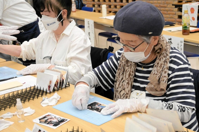 泥に漬かるなどした写真を洗う参加者＝コープカルチャー生活文化センター