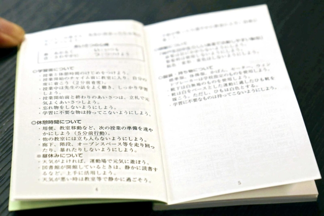 休憩時間の過ごし方などの校則を記載した生徒手帳＝神戸市内