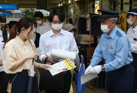 情報提供を求めてビラを配る警察官＝神戸市北区藤原台中町１