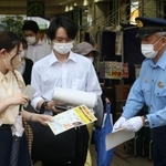 情報提供を求めてビラを配る警察官＝神戸市北区藤原台中町１