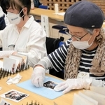泥に漬かるなどした写真を洗う参加者＝コープカルチャー生活文化センター