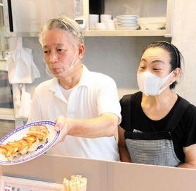 ギョーザを提供する張克正さん、田路利加子さん夫妻＝神戸市兵庫区東山町２