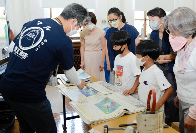 「かなしきデブ猫ちゃん」の連載紙面でバッグを作る参加者ら＝神戸市灘区王子町３