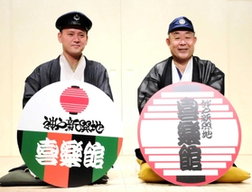 喜楽館のヘッドマークを手にする桂梅団治さん（右）と桂しん吉さん＝神戸市兵庫区新開地２