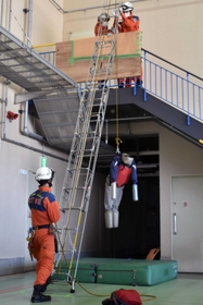 落下事故が起きた火災現場での救助方法を再現する隊員たち＝神戸市中央区神戸空港