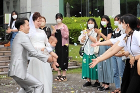 学生らから祝福を受け、幸せいっぱいの笑みを浮かべる新郎新婦＝神戸市西区