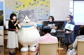 デブ猫「マル」から祝福を受ける潮崎孝代さん（左）ら＝神戸市灘区王子町３