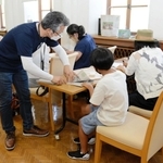 「かなしきデブ猫ちゃん」の連載紙面でバッグを作る参加者ら＝神戸市灘区王子町３