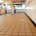 ＪＲ住吉駅につながる連絡通路の床に記された「東京」の駅名表示。奧に「横浜」「国府津」と続く＝ＪＲ住吉駅前