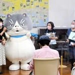 デブ猫「マル」から祝福を受ける潮崎孝代さん（左）ら＝神戸市灘区王子町３