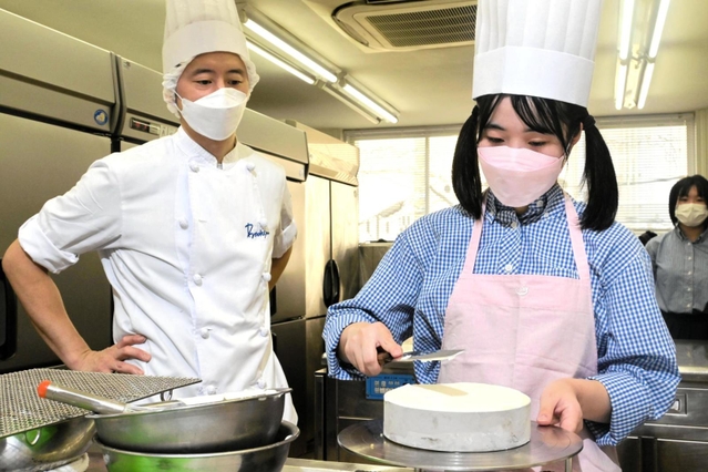 ケーキの飾り付けに挑戦する吉野咲枝さん＝ボックサン東須磨本店