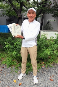 過去の記念誌を手にする吉野宏会長＝神戸市灘区王子町２、神戸登山研修所