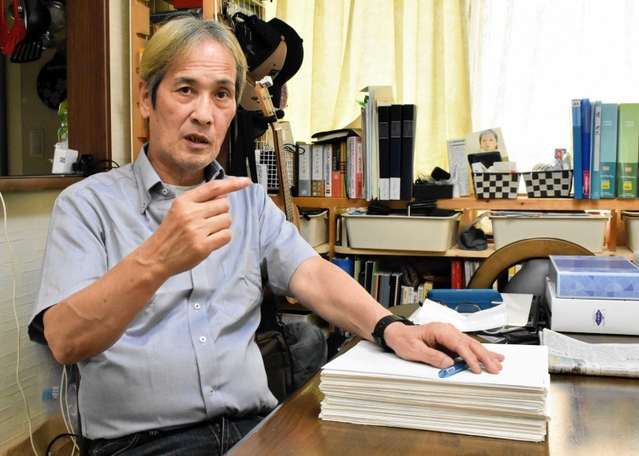 事件に関する書類を前に１２年を振り返る堤敏さん＝神戸市北区