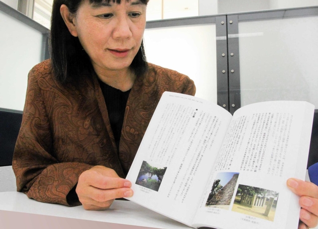 国内観光地の案内内容をまとめた「通訳ガイドと行く　日本世界遺産と歴史の旅」を手にする武村陽子さん＝神戸市内