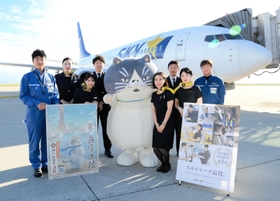 スカイマーク機をバックにパイロットや客室乗務員らと記念撮影するマル＝神戸空港