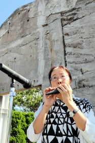 神戸の壁の前でオカリナを演奏する勝尾恵理子さん＝淡路市小倉