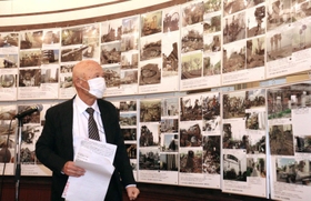 阪神・淡路大震災直後と復興後の写真を対比し、震災遺構保存の大切さを訴える三原泰治さん＝神戸市長田区腕塚町５