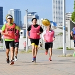 目標タイムが示されたビブスや風船の感覚を確かめながら走る神戸マランソンのペースセッター＝神戸市中央区脇浜海岸通１