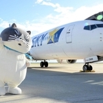 スカイマークの機体をバックに手を振るマル＝神戸空港