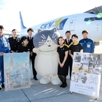 スカイマーク機をバックにパイロットや客室乗務員らと記念撮影するマル＝神戸空港