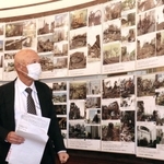 阪神・淡路大震災直後と復興後の写真を対比し、震災遺構保存の大切さを訴える三原泰治さん＝神戸市長田区腕塚町５