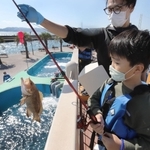 水槽から魚を釣り上げた利用客。明石海峡を眺めながら開放感のある釣りが楽しめる＝神戸市垂水区海岸通、マリンピア神戸さかなの学校