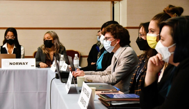 担当する国の意見や利害を念頭に置きながら議論を進める学生たち＝神戸市中央区