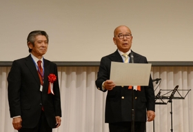 同窓会創立５０周年記念式典で辻正次学長から感謝状を受け取り、あいさつする同窓会の山本顕一会長（右）＝神戸ベイシェラトン＆タワーズ