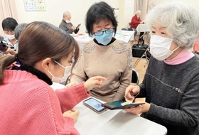 学生にスマホ操作を教わる地域住民ら＝神戸市灘区篠原北町２