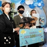 １００万人目の来館者に記念品を贈る中山寛美館長（左端）＝アトア