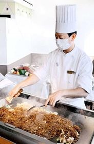 船内で神戸名物のぼっかけ焼きそばを作るシェフ＝ルミナス神戸２船内